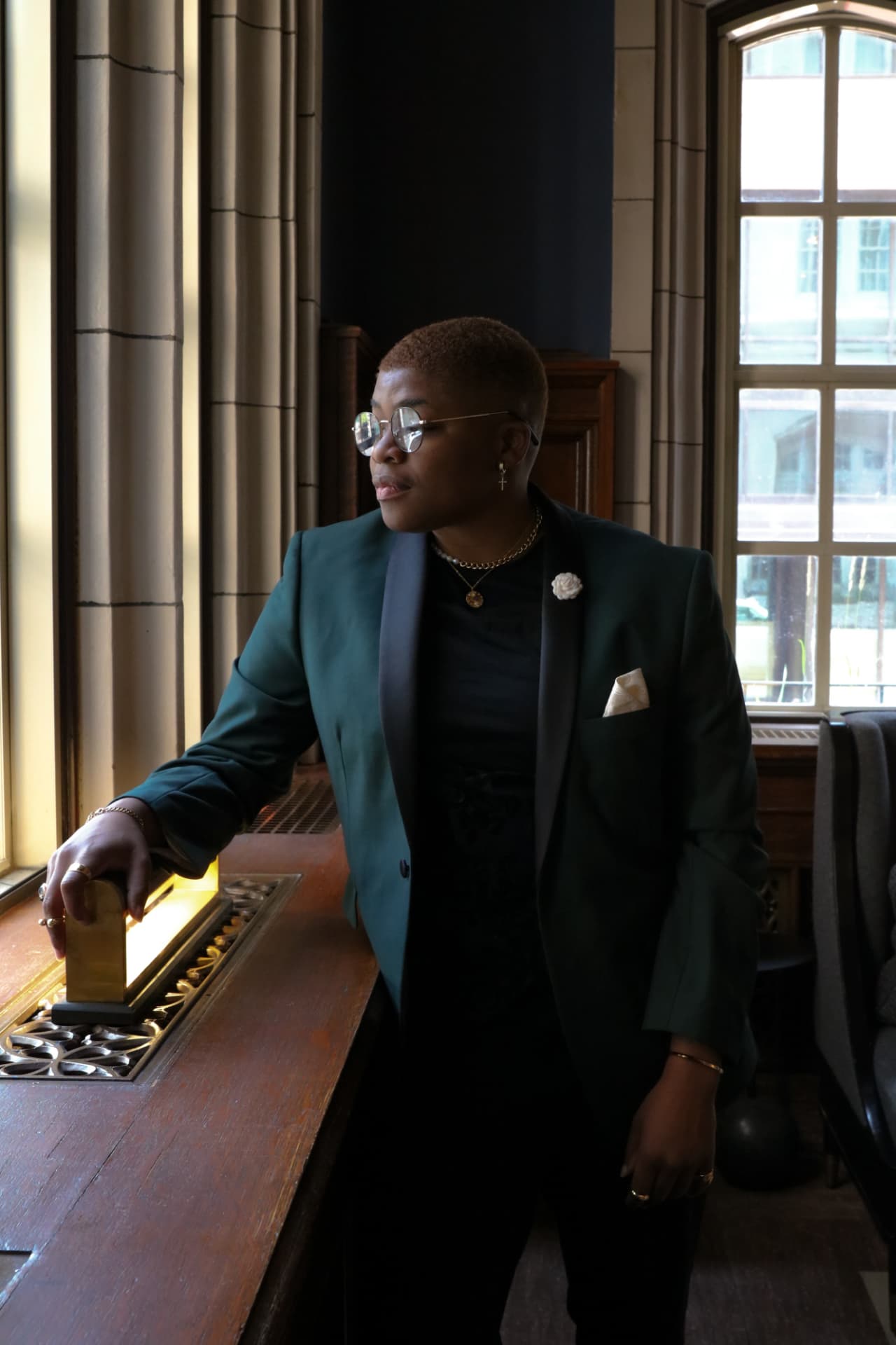 Jannae Gammage in a green tuxedo jacket by a sunlit window